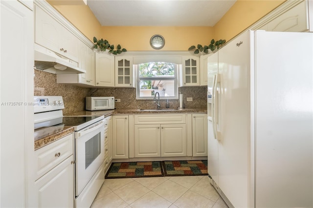 kitchen with light tile patterned flooring, tasteful backsplash, white cabinetry, sink, and white appliances