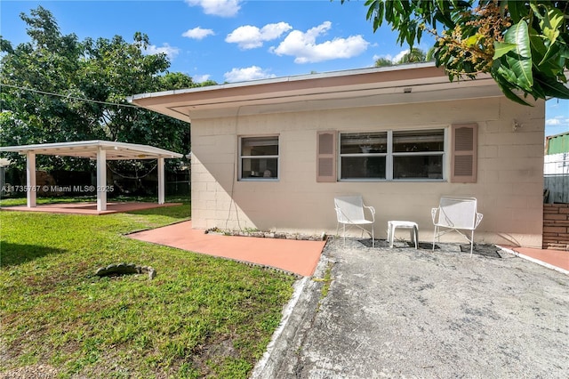 back of property featuring a patio area and a lawn