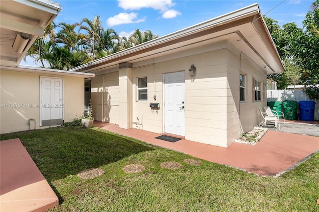 doorway to property featuring a lawn