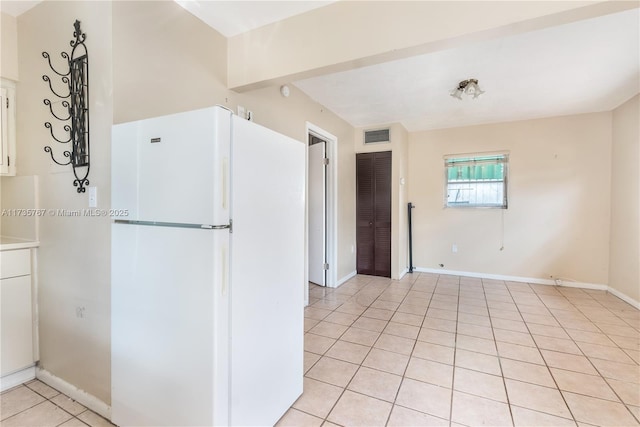 kitchen with light tile patterned flooring and white refrigerator