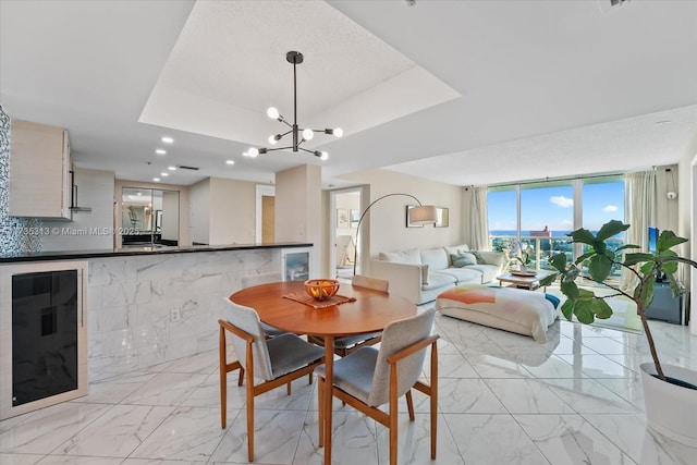 dining room with a raised ceiling and a notable chandelier