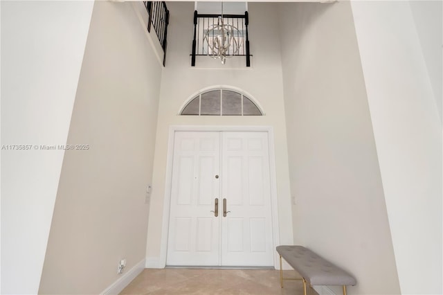 interior space featuring a towering ceiling and a chandelier