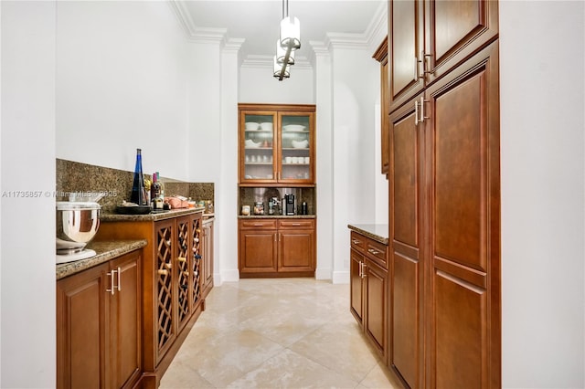 bar featuring hanging light fixtures, ornamental molding, dark stone countertops, and decorative backsplash