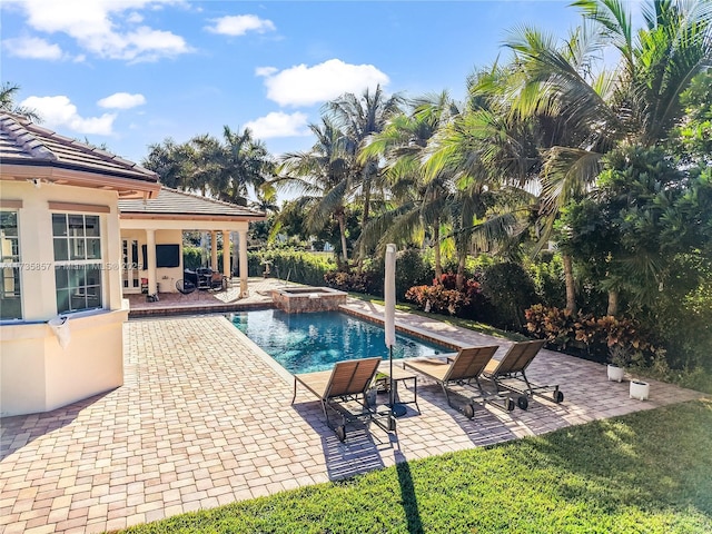 view of swimming pool featuring an in ground hot tub and a patio