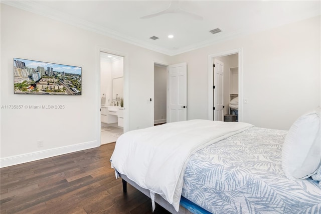 bedroom featuring connected bathroom, dark hardwood / wood-style flooring, a spacious closet, ceiling fan, and crown molding