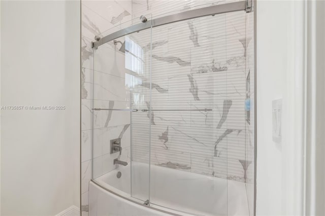 bathroom with bath / shower combo with glass door