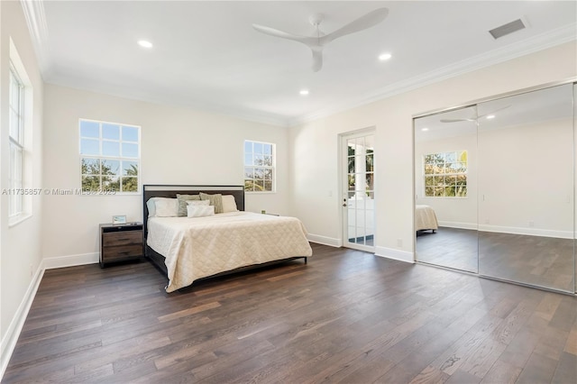 bedroom with dark hardwood / wood-style flooring, crown molding, and ceiling fan