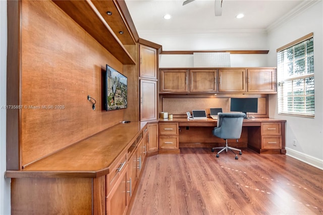 office with crown molding, built in desk, light hardwood / wood-style floors, and ceiling fan