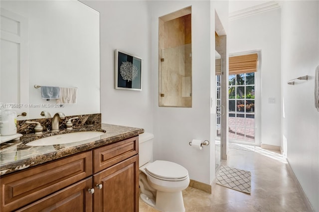 bathroom with vanity, a shower with door, and toilet