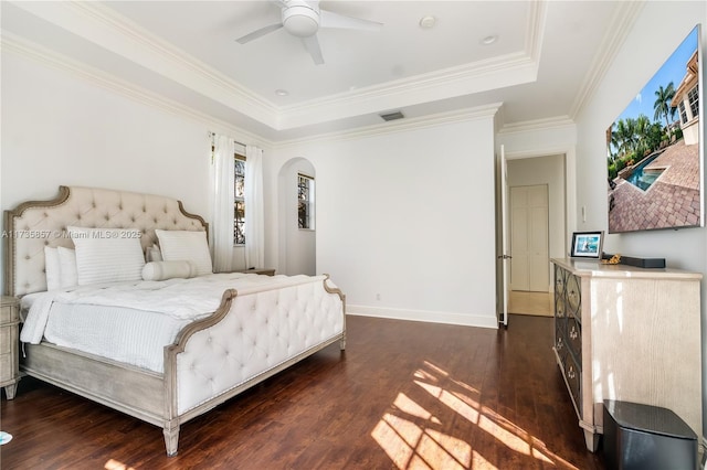 bedroom featuring crown molding, ceiling fan, a tray ceiling, and dark hardwood / wood-style flooring