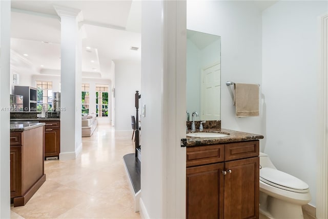 bathroom with decorative columns, vanity, toilet, crown molding, and tile patterned floors