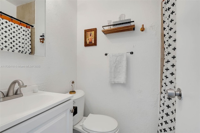 bathroom featuring vanity, toilet, and curtained shower