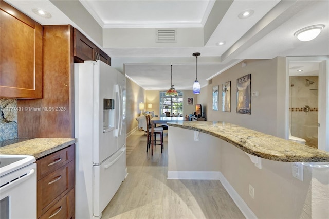 700 SE 6th Ave Unit 203, Deerfield Beach, FL 33441 - kitchen featuring light stone counters, pendant lighting, white refrigerator with ice dispenser, visible vents, and brown cabinetry