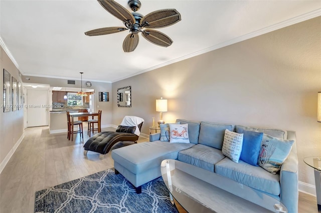 700 SE 6th Ave Unit 203, Deerfield Beach, FL 33441 - living area with ornamental molding, light wood-style flooring, baseboards, and a ceiling fan