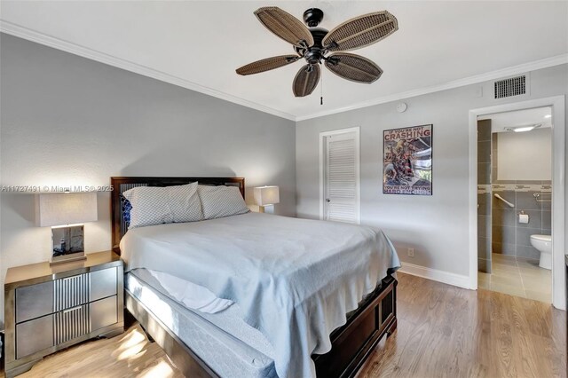 700 SE 6th Ave Unit 203, Deerfield Beach, FL 33441 - bedroom featuring ceiling fan, light wood-style flooring, visible vents, ensuite bath, and crown molding