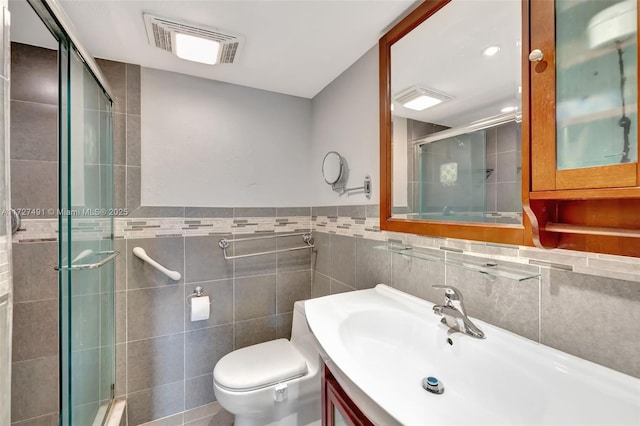 700 SE 6th Ave Unit 203, Deerfield Beach, FL 33441 - full bath featuring visible vents, tiled shower, toilet, vanity, and tile walls