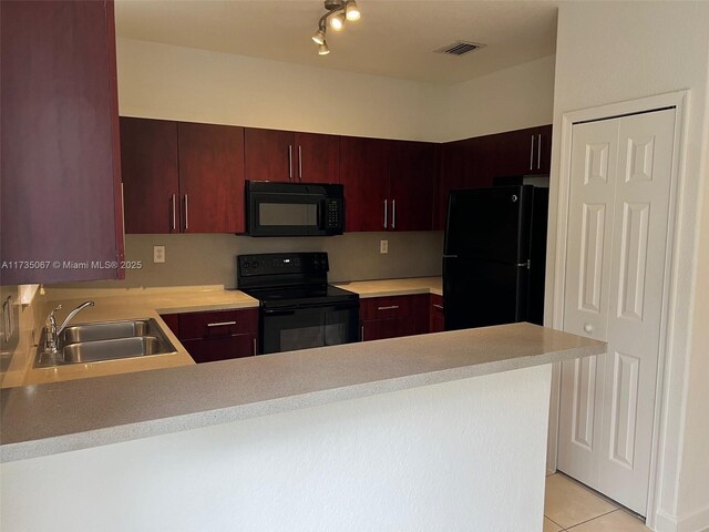 kitchen with sink, kitchen peninsula, light tile patterned floors, and black appliances