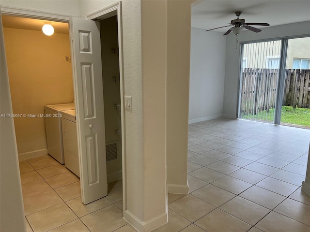 laundry area featuring light tile patterned floors, washer and clothes dryer, and ceiling fan