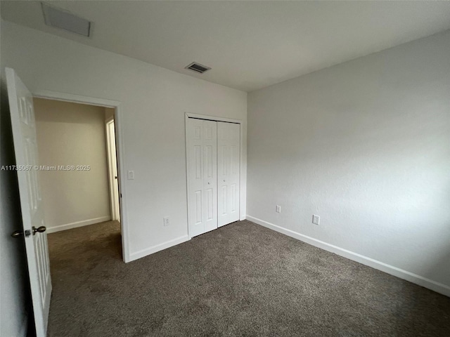 unfurnished bedroom featuring a closet and dark colored carpet