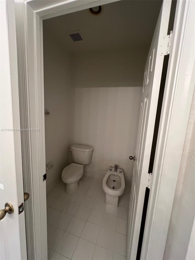 bathroom featuring a bidet, tile patterned floors, and toilet