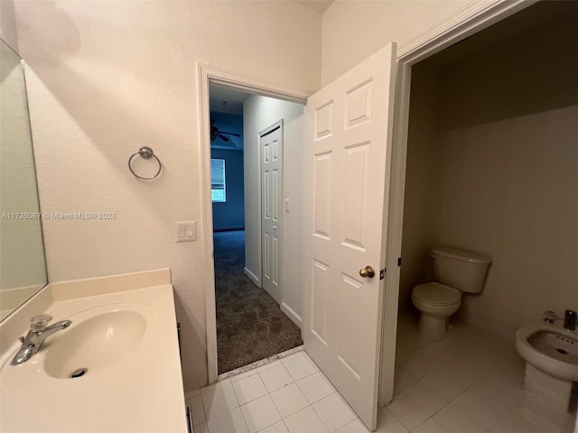 bathroom featuring a bidet, tile patterned floors, toilet, and sink