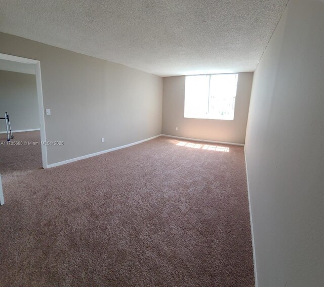 carpeted spare room with a textured ceiling