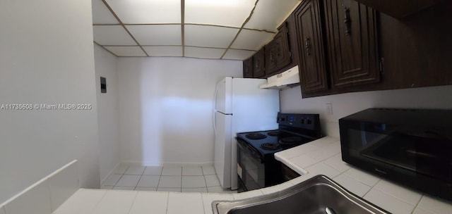 kitchen with light tile patterned flooring, dark brown cabinets, electric range, tile counters, and a drop ceiling