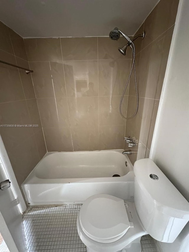 bathroom with tile patterned floors, toilet, and tiled shower / bath combo