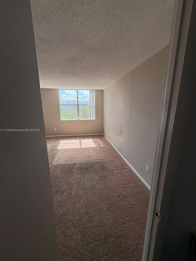 carpeted spare room featuring a textured ceiling