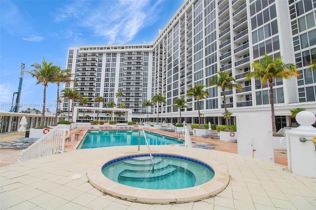 view of swimming pool with a community hot tub and a patio area