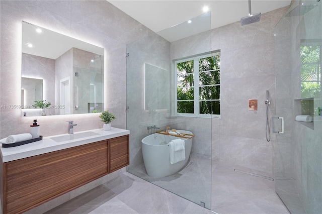 bathroom with vanity, plus walk in shower, and tile walls