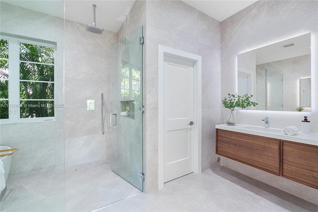 bathroom featuring tile walls, vanity, and walk in shower