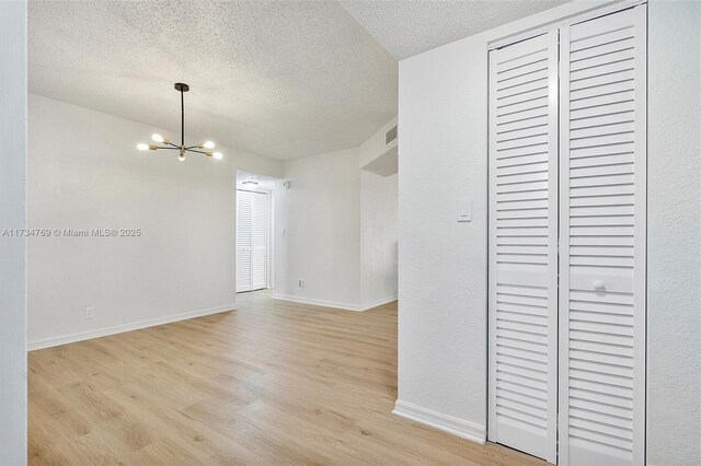 4050 NW 42nd Ave Unit 318, Fort Lauderdale, FL 33319 - unfurnished room featuring a chandelier, a textured ceiling, and light wood-type flooring
