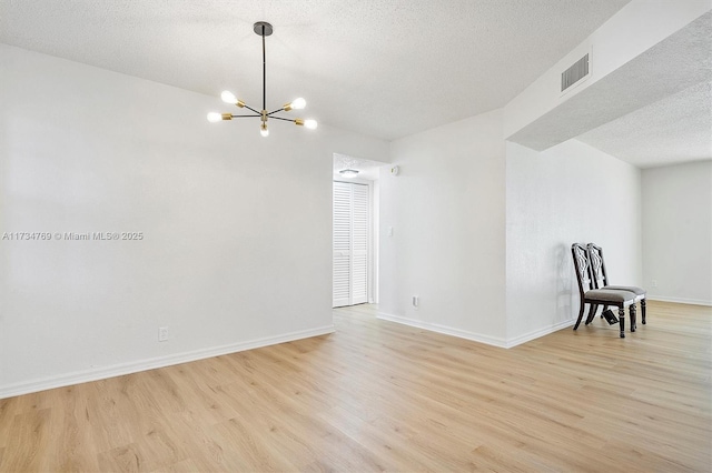 4050 NW 42nd Ave Unit 318, Fort Lauderdale, FL 33319 - empty room featuring light hardwood / wood-style floors, a chandelier, and a textured ceiling