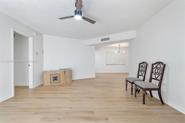 4050 NW 42nd Ave Unit 318, Fort Lauderdale, FL 33319 - living area featuring ceiling fan with notable chandelier, a textured ceiling, and light wood-type flooring