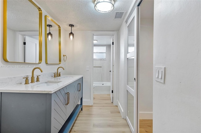 4050 NW 42nd Ave Unit 318, Fort Lauderdale, FL 33319 - bathroom featuring vanity, hardwood / wood-style floors, and a textured ceiling