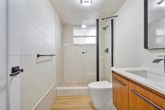 4050 NW 42nd Ave Unit 318, Fort Lauderdale, FL 33319 - bathroom with a textured ceiling, wood-type flooring, toilet, and tiled shower