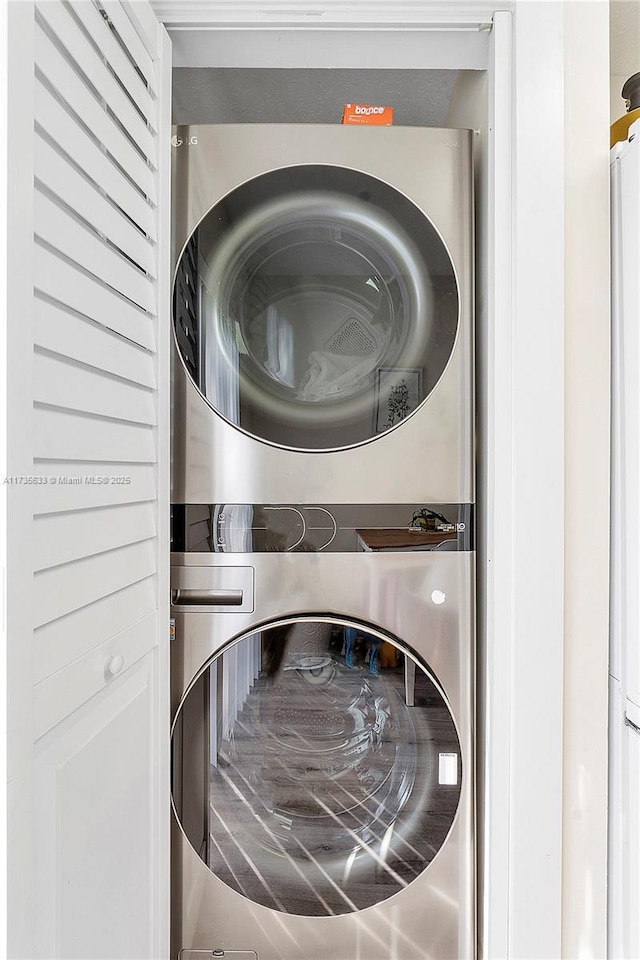 clothes washing area with stacked washer and dryer