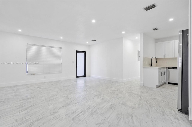 unfurnished living room featuring sink