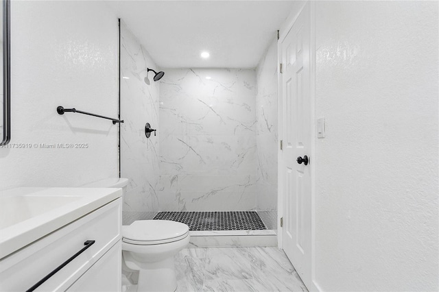 bathroom with vanity, toilet, and a tile shower