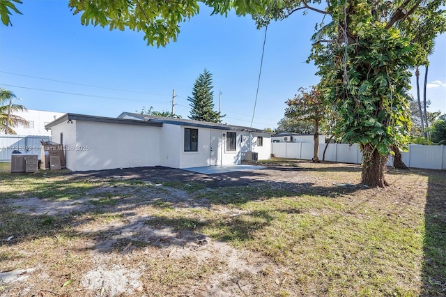 rear view of house featuring a yard, a patio, and central air condition unit