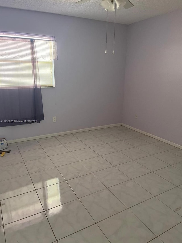 spare room featuring ceiling fan and a textured ceiling