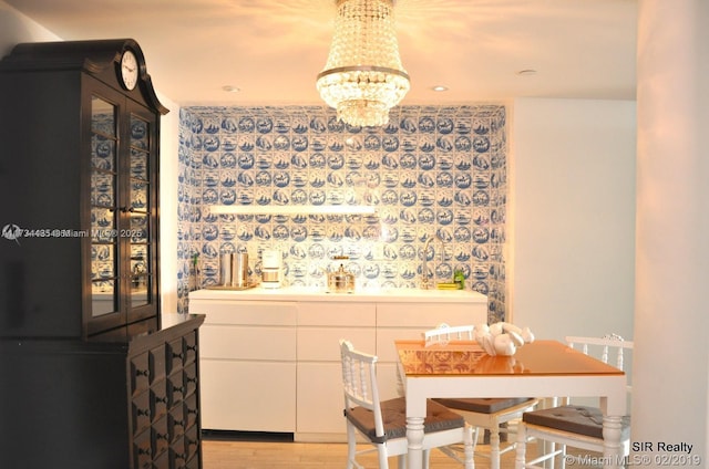 dining space with an inviting chandelier and light hardwood / wood-style floors