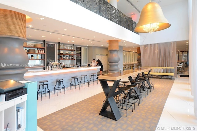 dining area with tile patterned flooring and a towering ceiling