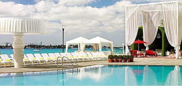 view of pool featuring a gazebo and a water view