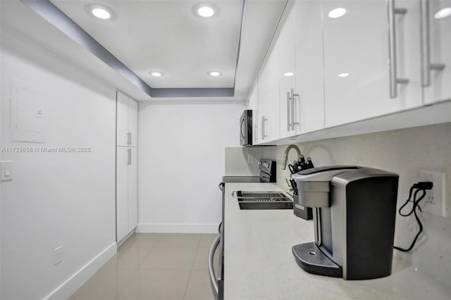 kitchen featuring light tile patterned flooring and white cabinets