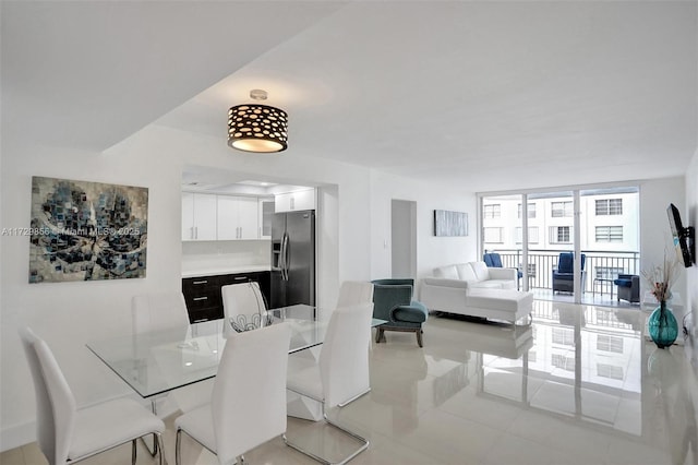 dining space with floor to ceiling windows and light tile patterned floors