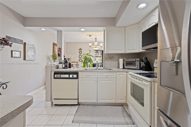 kitchen featuring sink, white cabinets, hanging light fixtures, light tile patterned floors, and white appliances