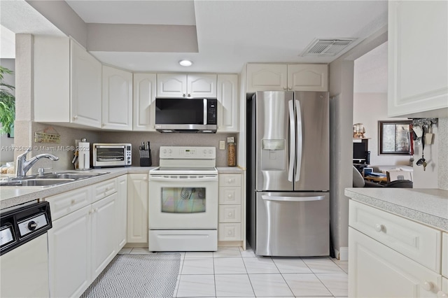 kitchen featuring white cabinetry, stainless steel appliances, sink, and light tile patterned floors