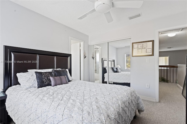 bedroom with ceiling fan, carpet flooring, a textured ceiling, and a closet